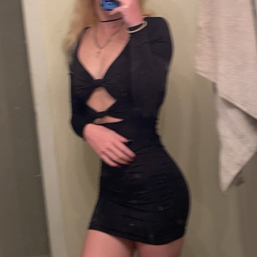 Black mini dress. Has cross tie openings in the front and very form fitting.
